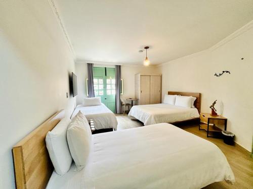 a hotel room with two beds and a table at Hotel Casa Quintana in Aguadas