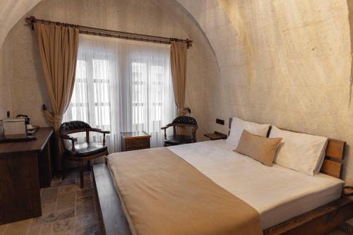 a bedroom with a large bed and a window at Noah's Ark Cave Hotel in Göreme