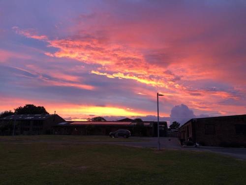 a sunset with a car parked in a parking lot at Another Place in Formby