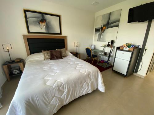 a bedroom with a large white bed and a desk at Departamento céntrico con la mejor vista. San Bernardino in San Bernardino