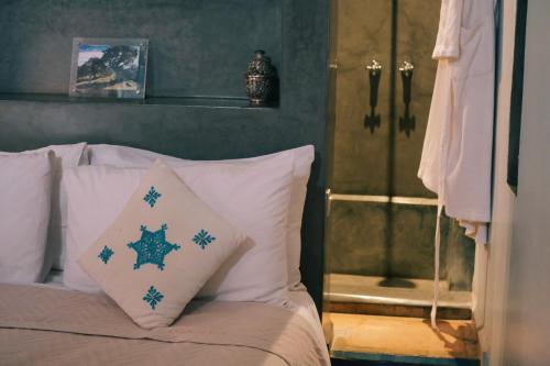 1 dormitorio con cama con almohadas y ducha en Riad is entire house for sole occupancy up to 6 adults & 2 children, en Marrakech