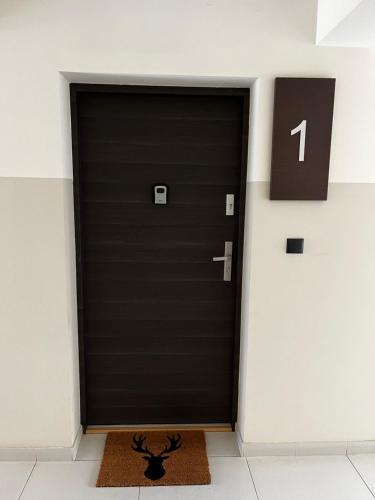 Una puerta negra en una habitación con una alfombra en la parte delantera en Złotów-ka, en Złotów