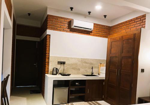 a kitchen with a sink and a brick wall at Coastal Hideaway in Midigama