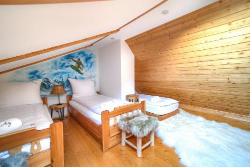 una camera con 2 letti e una parete in legno di Aloj Zakopane by Loft Affair a Zakopane