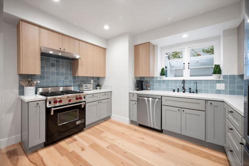 a kitchen with stainless steel appliances and wood cabinets at Chic 3BR Oasis in Studio City:Toluca Lake Adjacent in Los Angeles