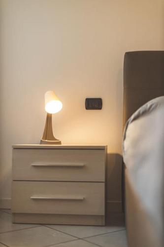 a lamp on top of a dresser next to a bed at Suite il Borgo [Monza - Milano] + Garage Privato in Desio