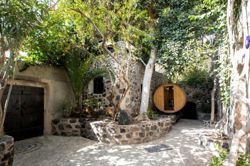 a garden with a stone building with trees and a table at Ducato Wine Village in Megalokhori