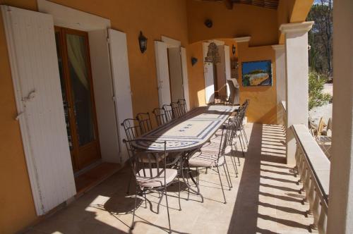 einen Tisch und Stühle auf der Veranda eines Hauses in der Unterkunft le Mas Provençal in Régusse