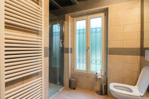 a bathroom with a toilet and a window at Appartamento Scaligero Mameli Borgo Trento in Verona