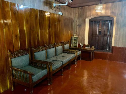 a row of chairs in a room with wooden walls at Vintage Vista in Lakkidi