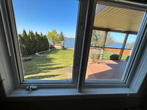 a window with a view of a yard at Waterfront cozy cottage. in Port Perry