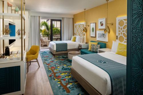 a hotel room with two beds and a living room at The Alfond Inn in Orlando