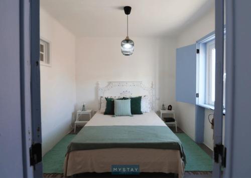 a bedroom with a large bed with a green blanket at MyStay - Cantinho do Açor in Vale de Açor