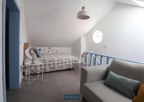 a bedroom with a bed and a table and a couch at MyStay - Cantinho do Açor in Vale de Açor
