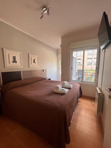Un dormitorio con una cama grande con dos toallas encima. en Este Apart, en Bahía Blanca