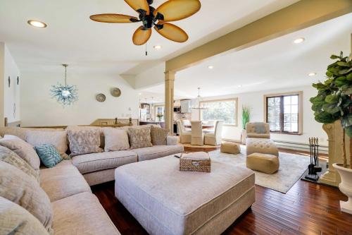 a living room with a large couch and a ceiling fan at Luxe Poconos Lake House with Private Beach in Pocono Summit