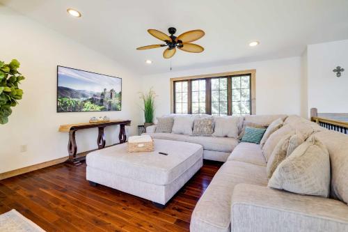 a living room with a couch and a ceiling fan at Luxe Poconos Lake House with Private Beach in Pocono Summit