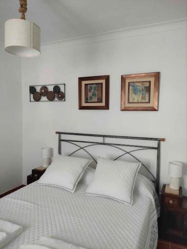 a bedroom with a bed with two pillows on it at Casa do Duque in Arneiro