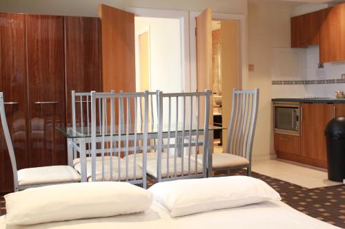 a kitchen with two chairs and a table with two pillows at Grand Plaza Serviced Apartments in London