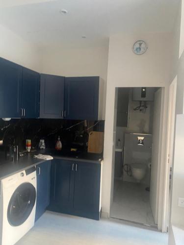 a kitchen with blue cabinets and a washing machine at good Time côte d'azur in Nice