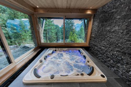 une baignoire jacuzzi dans une chambre avec fenêtre dans l'établissement Chalet Krystal, aux Carroz d'Arâches