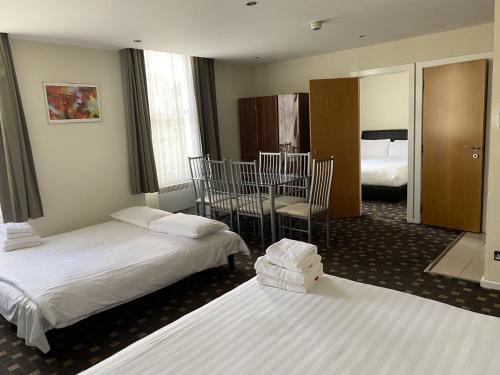 a hotel room with two beds and two chairs at Grand Plaza Serviced Apartments in London