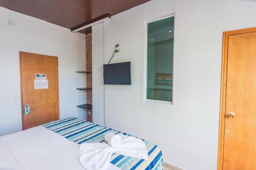 a bedroom with a bed with a towel on it at Hotel Guatatur in Guatapé