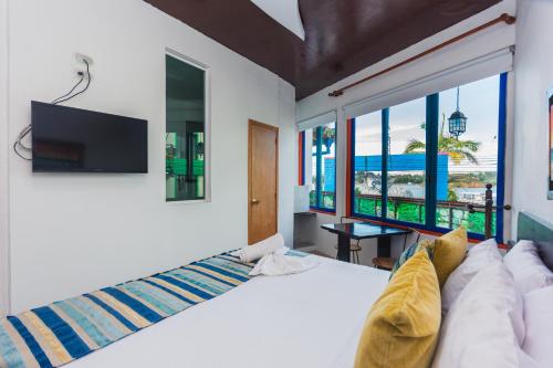 a bedroom with a large bed and a tv at Hotel Guatatur in Guatapé