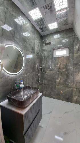 uma casa de banho com um lavatório e um espelho em Gabala 7 Villa em Vǝndam