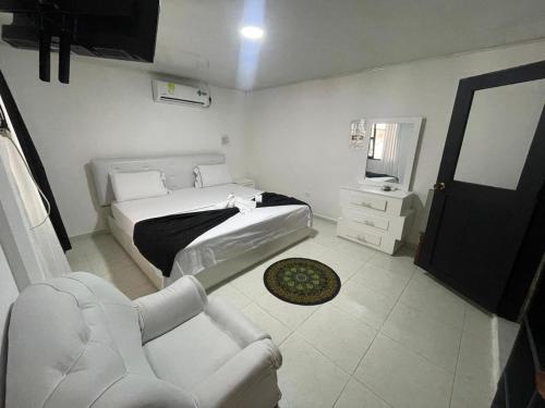 een slaapkamer met een bed, een stoel en een spiegel bij POSADA TURISTICA LAS VEGAS in Inírida