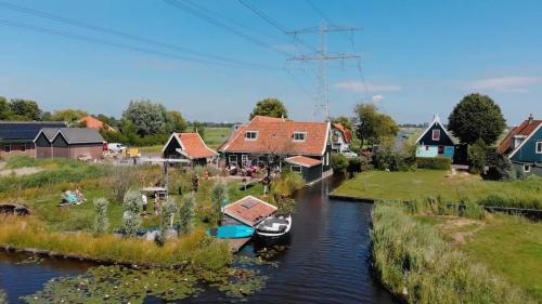 a village with houses and boats in a river at Boutique Hotel Jongwijs Westzaan in Westzaan