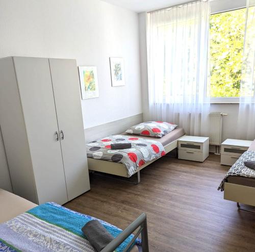 Habitación pequeña con 2 camas y ventana en Apartment am Bahnhof und Uniklinik, en Mainz