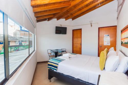 a bedroom with a bed and a window at Hotel Guatatur in Guatapé