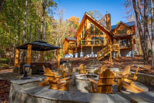 a log cabin in the woods with tables and chairs at Brewer Hollow in Lake Lure