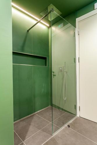a green shower with a glass door in a bathroom at Le Texture Premium Rooms Duomo-Cordusio in Milan