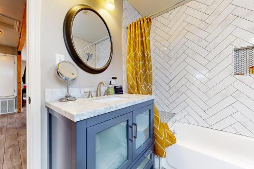baño con armario azul y espejo en Meadow Creek Cottage en Wimberley