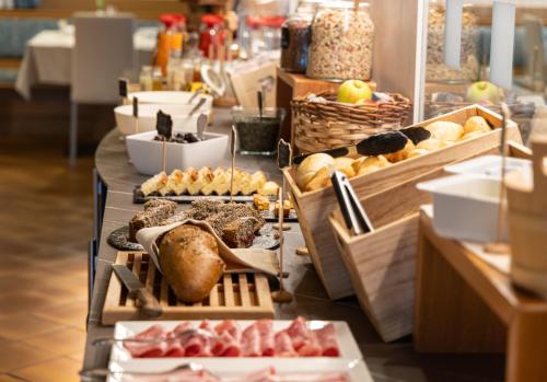 een buffet met verschillende soorten brood en zoete deegwaren bij Hotel Panorama in San Martino di Castrozza