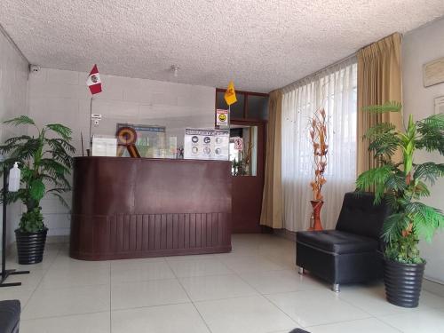 una sala de espera con recepción y plantas en Hospedaje San Camilo Tacna, en Tacna