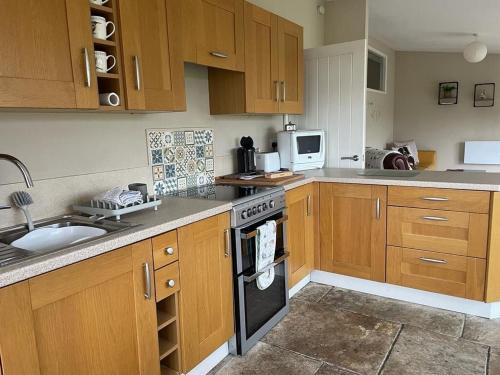 a kitchen with wooden cabinets and a stove top oven at Let It Be in Liverpool