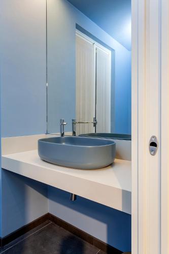 a blue bathroom with a sink and a mirror at Le Texture Premium Rooms Duomo-Cordusio in Milan