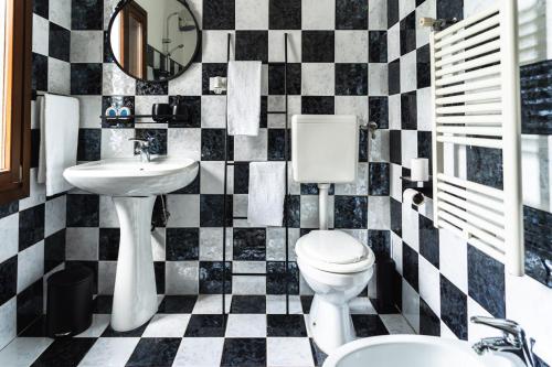 een badkamer met een toilet, een wastafel en een spiegel bij [Angolo45]Vista Inedita su Udine in Passons