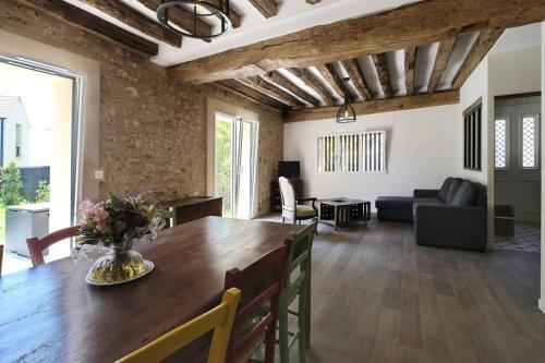 a dining room with a wooden table and a living room at Le Gîte - Le Pressoir in Les Molières