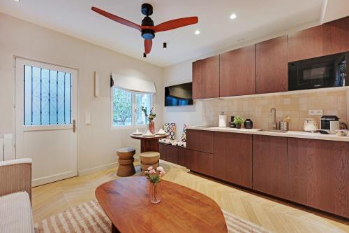 Il comprend une cuisine équipée d'un ventilateur de plafond et d'une table en bois. dans l'établissement Superbe T2 Opéra Cadet, à Paris