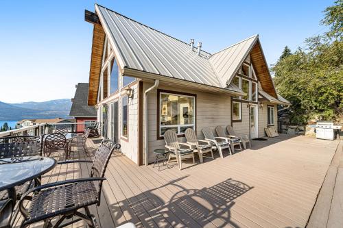 a deck with chairs and tables and a house at Mac's Place in Manson