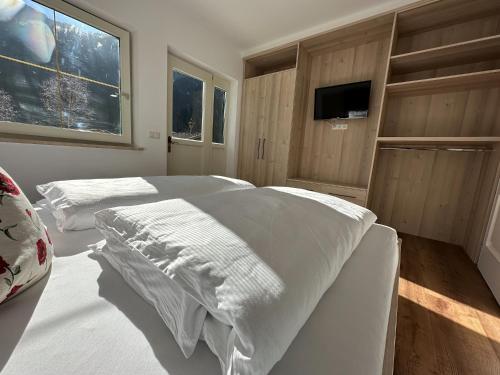 1 Schlafzimmer mit 2 Betten und einem Flachbild-TV in der Unterkunft Appartementhaus Zillertal by PiaundDirk in Finkenberg