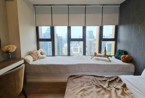 Schlafzimmer mit einem großen Fenster mit Stadtblick in der Unterkunft Ceylonz Suites KL Bukit Bintang in Kuala Lumpur