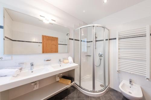 ein Bad mit 2 Waschbecken und einer Dusche in der Unterkunft Tommelehof in Algund
