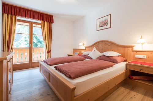 ein Schlafzimmer mit einem großen Bett und einem Fenster in der Unterkunft Tommelehof in Algund