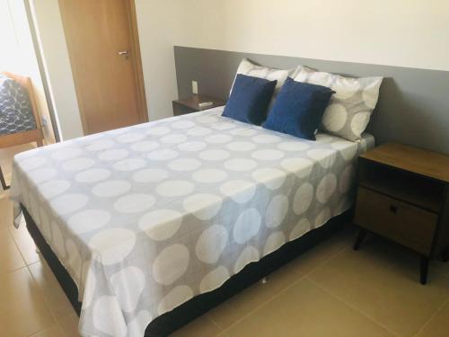 - une chambre avec un grand lit et des oreillers bleus dans l'établissement Loft Beira Mar, à Camassari