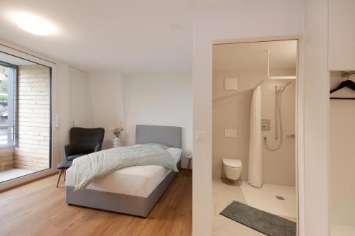 a bedroom with a bed and a bathroom with a shower at Bären Herisau GmbH in Herisau